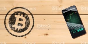 Cryptocurrency concept (A smartphone with Bitcoin chart displayed and on the plank)2